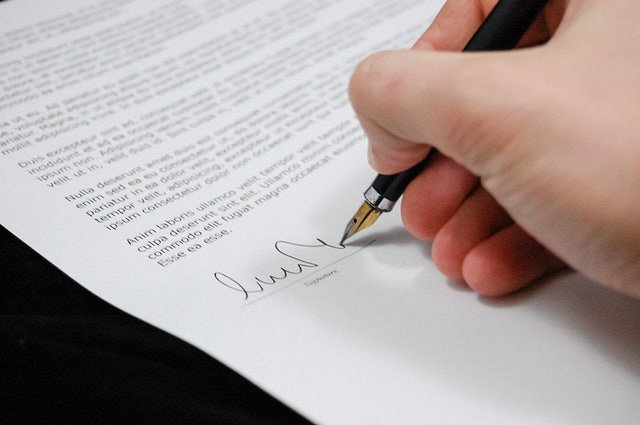 Pozew rozwodowy Lublin oraz osoba podpisująca dokument na białej kartce papieru